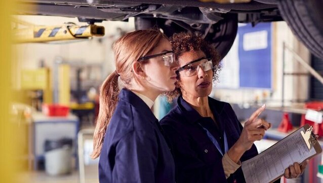 zwei Personen arbeiten in einer Autowerkstatt